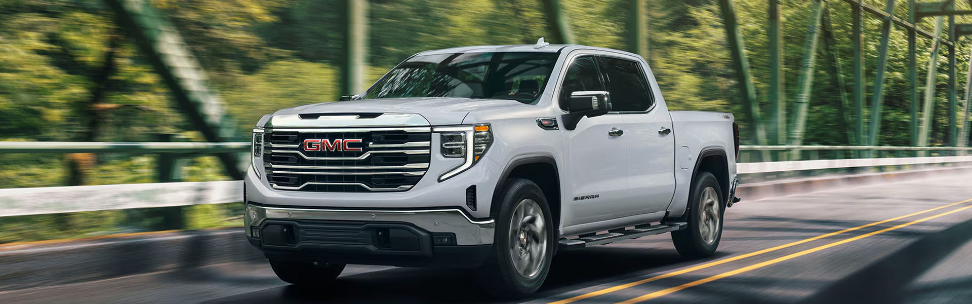 GMC Sierra pickup truck driving on road.